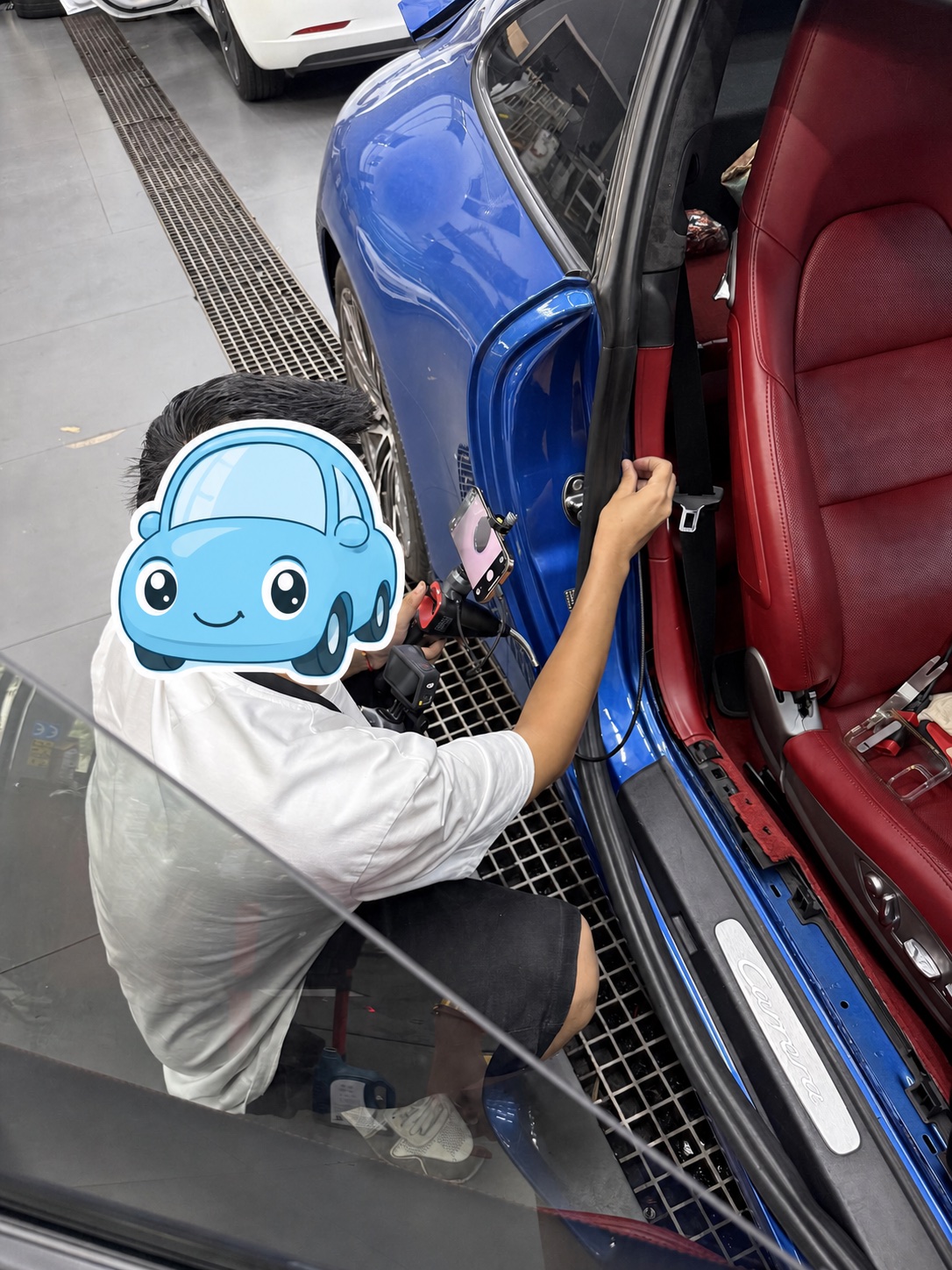 Inspector using a camera tool to check the door-side cavity of the blue Porsche 911 Carrera