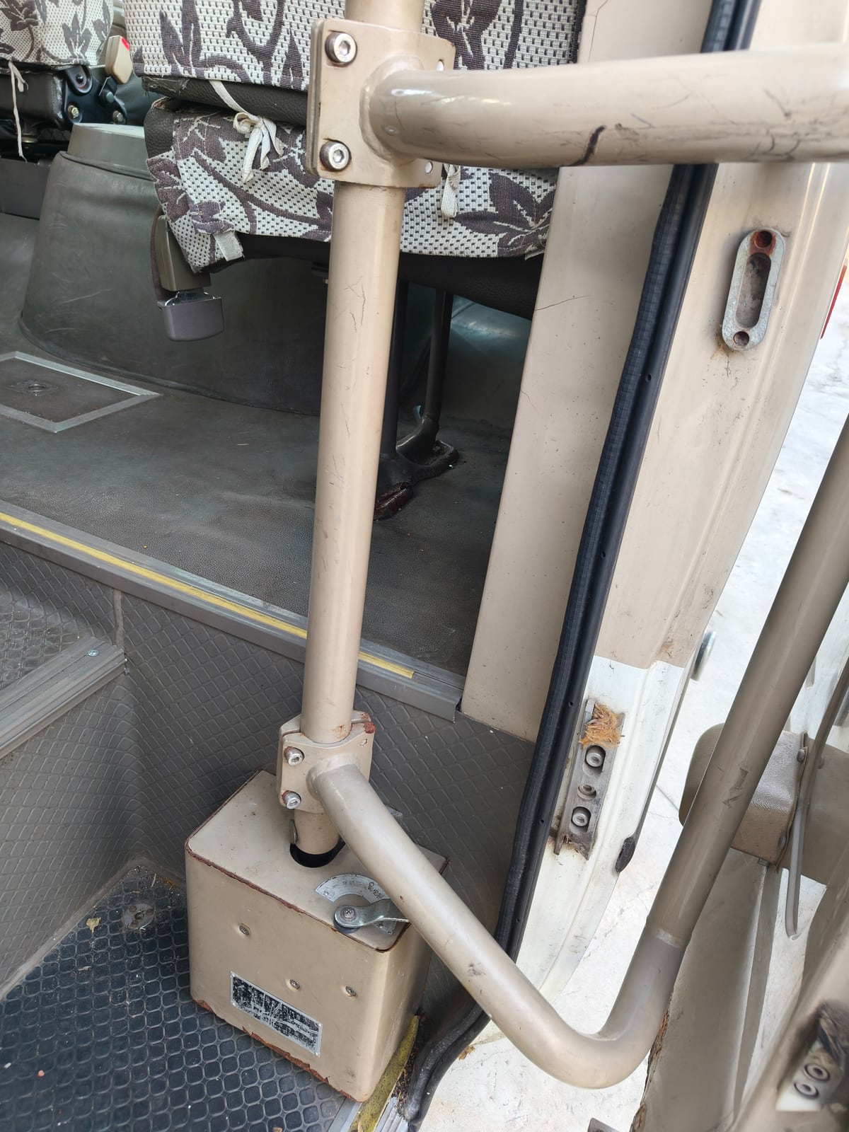 Entrance door, handrail and step condition inside a used Coaster-style bus