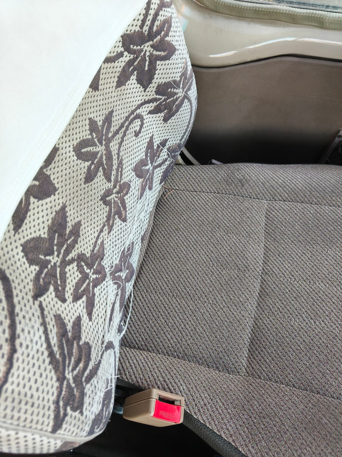 Worn seat upholstery inside a used Coaster-style bus before refurbishment