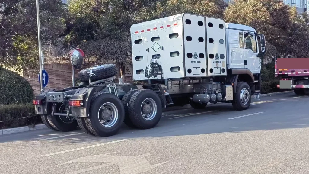 White Sinotruk HOWO CNG tractor truck viewed from the rear side, showing the cylinder enclosure