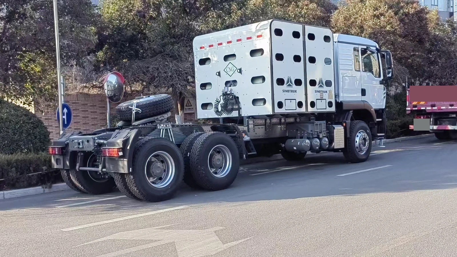 White Sinotruk HOWO CNG tractor truck viewed from the rear side, showing the cylinder enclosure