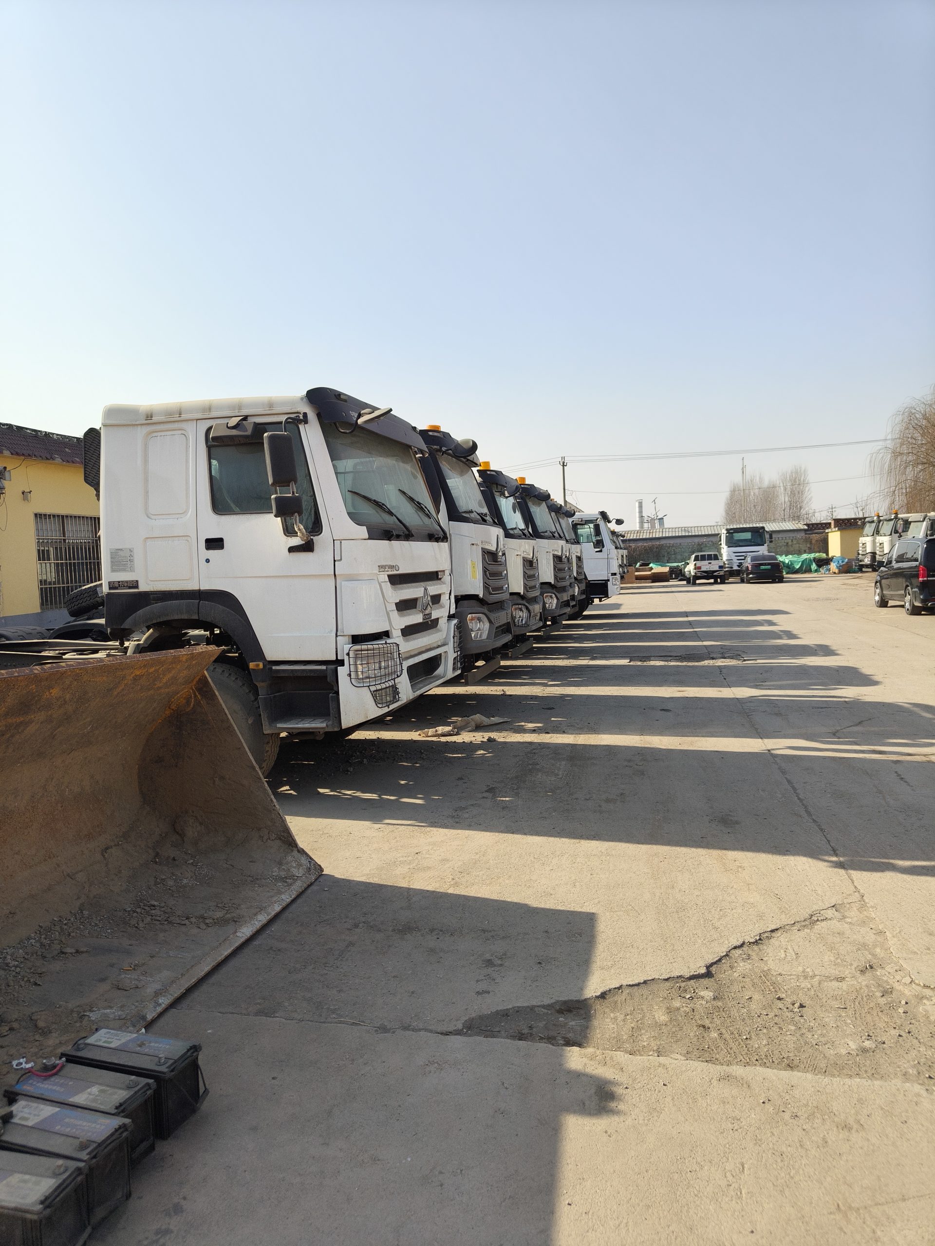 Row of HOWO trucks at a supplier facility visited in Shandong